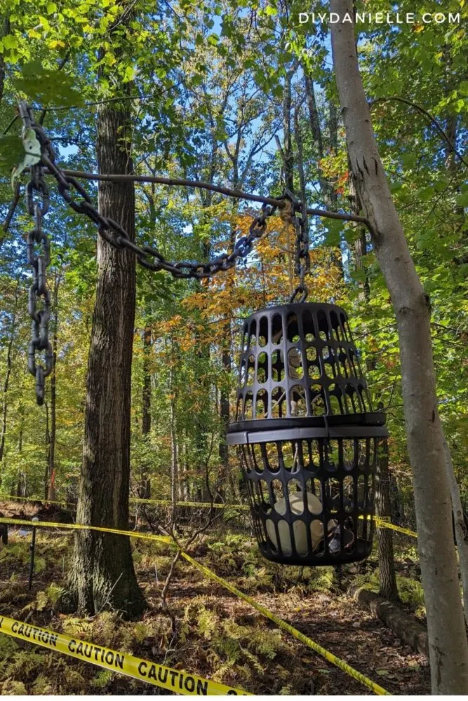 Skeletons hanging in cages from a tree on the haunted trail.