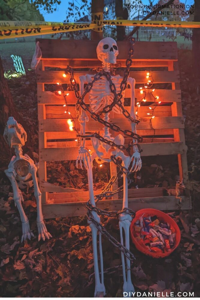 Skeleton chained up to pallet with a skeletal dog.
