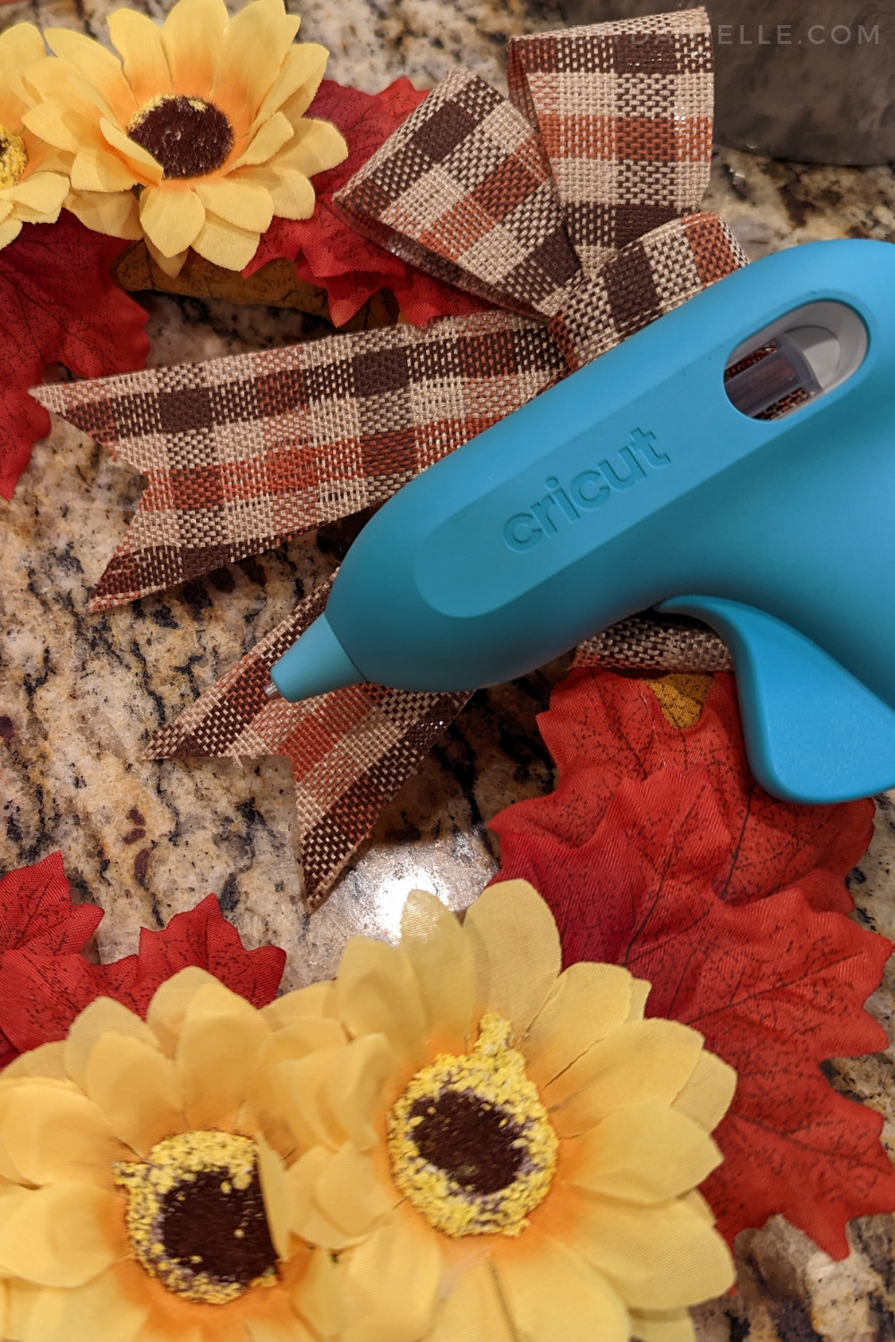 Using Cricut glue gun to attach the Fall bow.