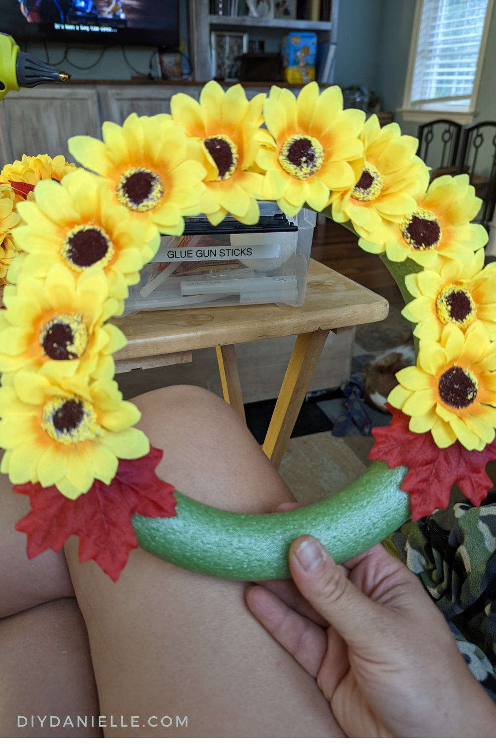 Adding sunflowers and fall leaves to a foam wreath form.