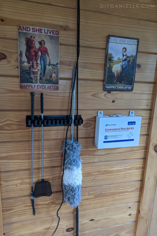 Barn decor, including a first aid kit, signs, and a whip rack.