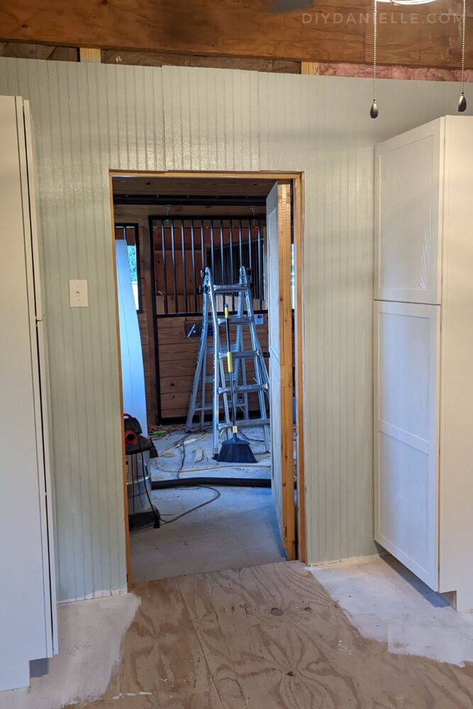 White shaker style cabinets to hide tack and office supplies.