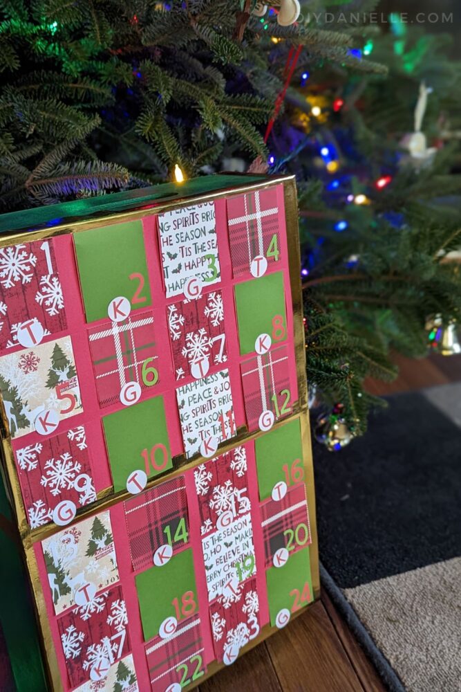 Advent Calendar made with my Cricut Maker 3, scrapbook paper, and a wood box. There's a sticker with the child's letter for opening the window that day.