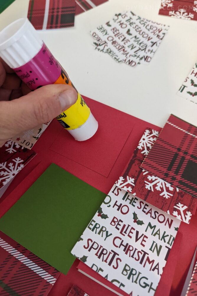 Gluing rectangles of Christmas themed scrapbook paper to the top of the Advent Calendar.