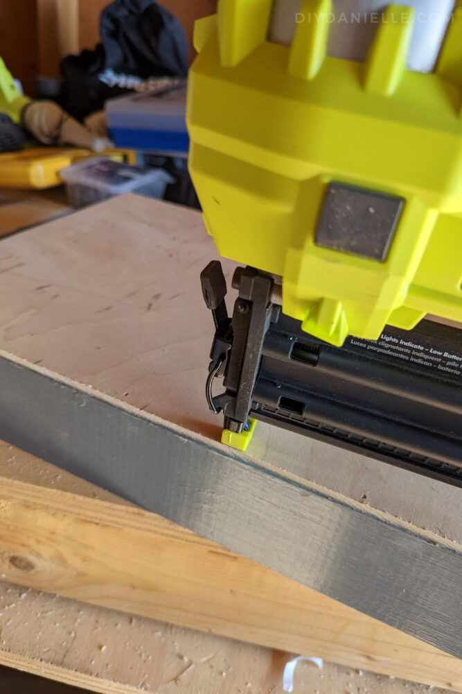 Using the Ryobi Airstrike to attach the 1/4" plywood to the back of the Cricut wall shelves.