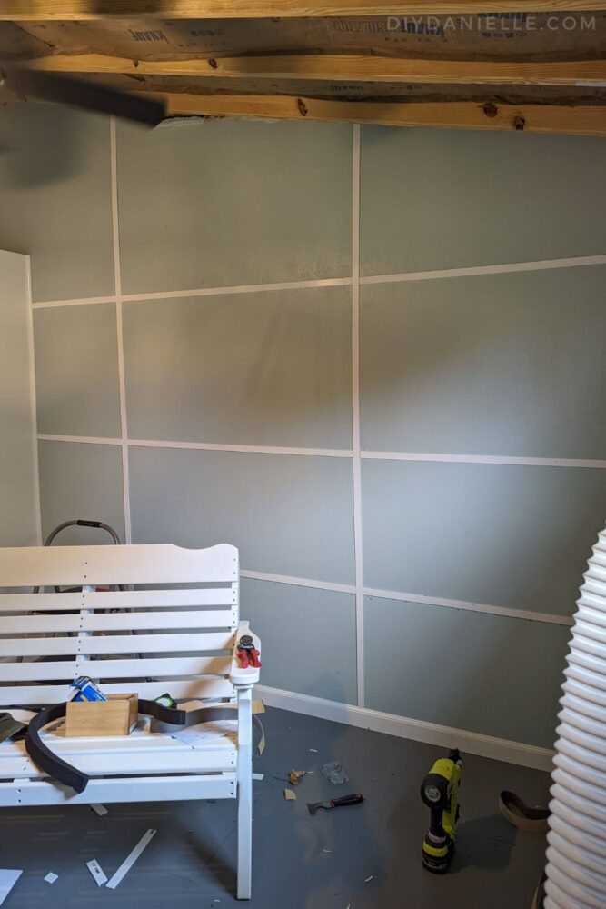 Plywood wall in a tack room, primed, painted light blue, then with white lattice strips covered the seams and screw heads.