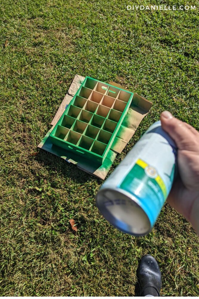 24 slot soda box being spray painted green to make an Advent Calendar.