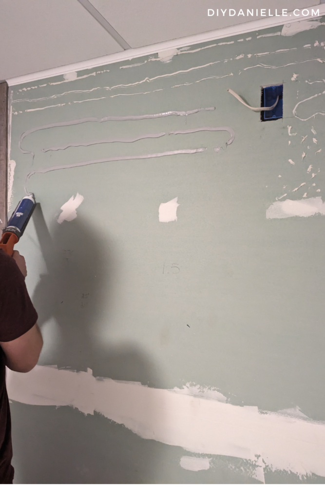 Applying construction adhesive for the wall panels.