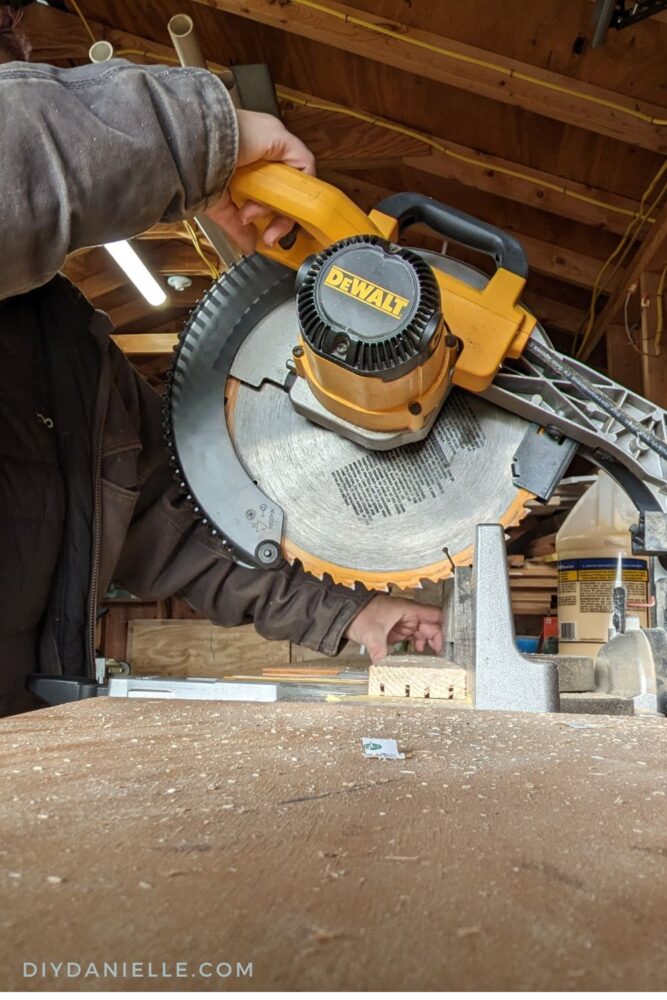 Using a Dewalt miter saw to make straight cuts in a 1x3 board that has 4 groove cuts in it to make many card holders.
