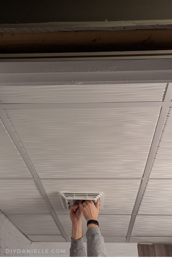Replacing the bathroom fan after installing a Genesis Drifts ceiling panel.