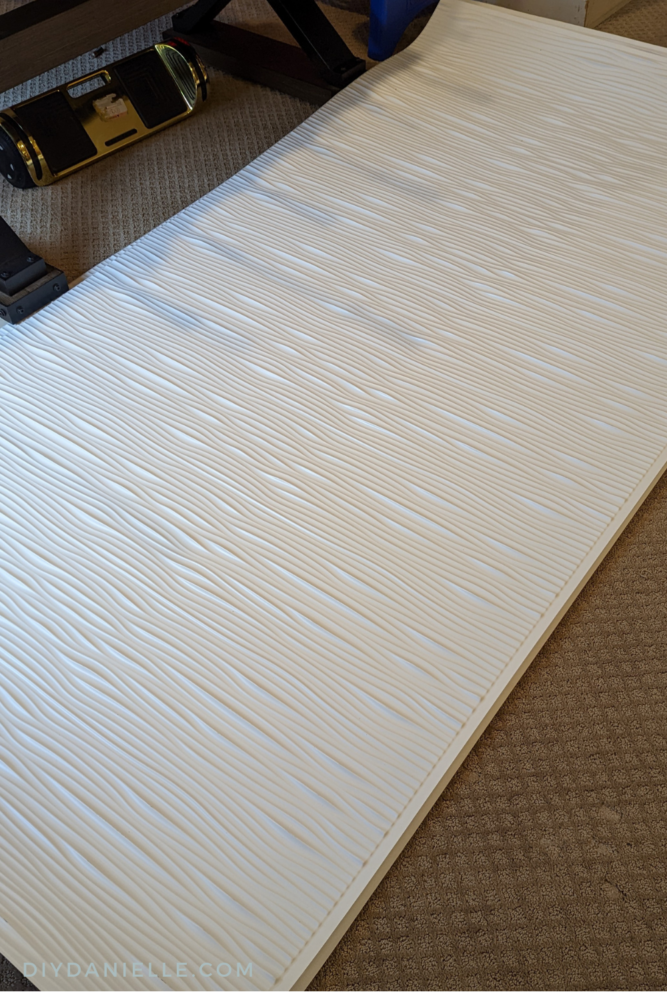 Fasade Panels in Matte White, Wave from the DIY Decor Store. They're being laid flat on the floor for 24 hours after being received so they can lay flat.
