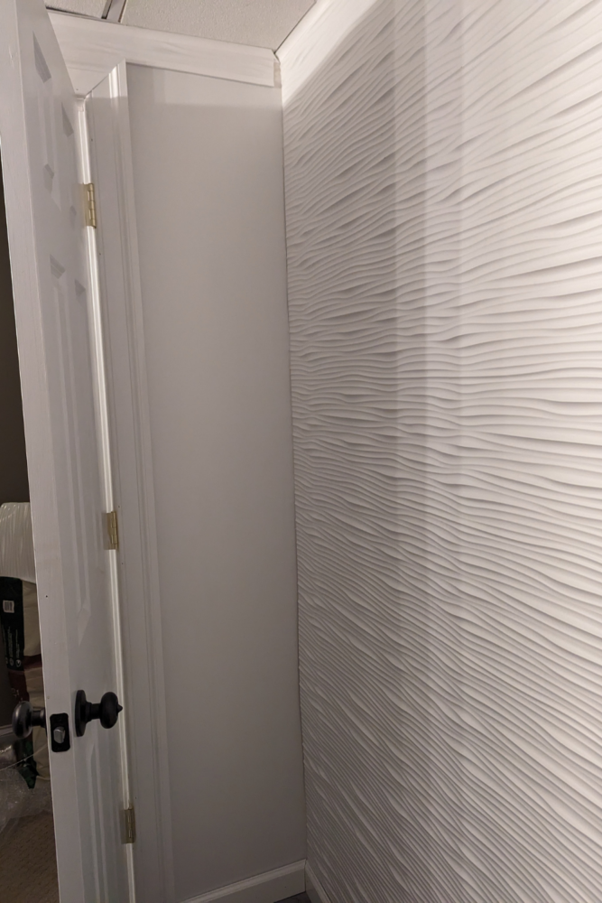 Primed and painted wall that is painted white. This is the area behind the bathroom door and the walls on the opposite sides are Fasade panels.