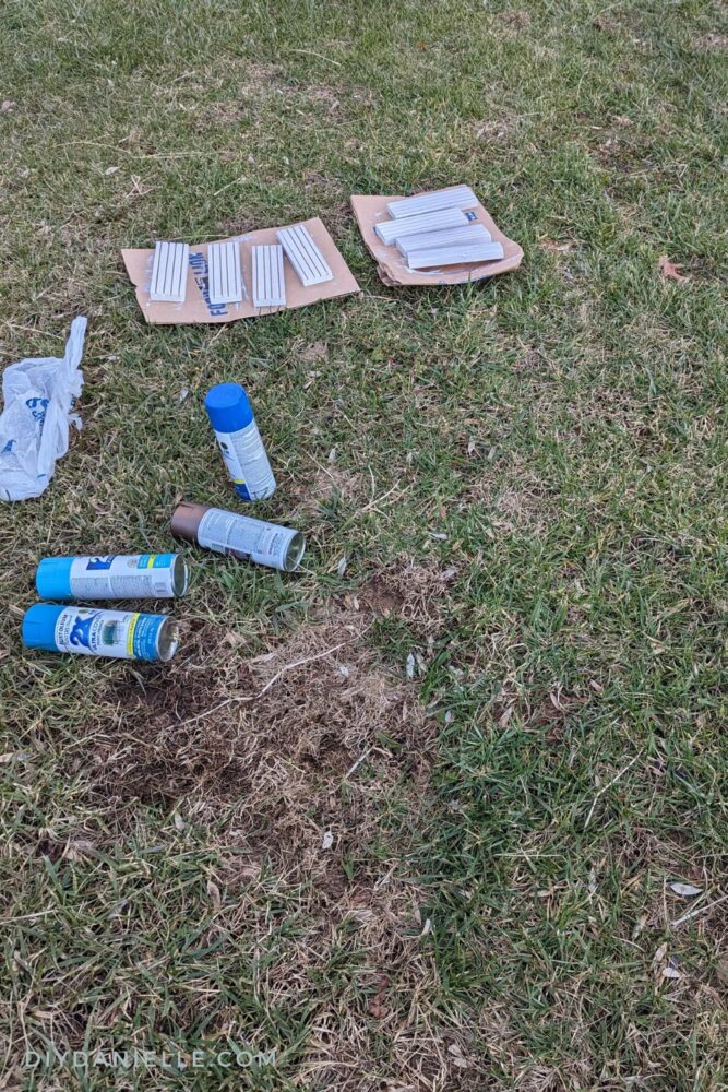 Priming and painting the playing card holders on the lawn (using paper bags underneath).