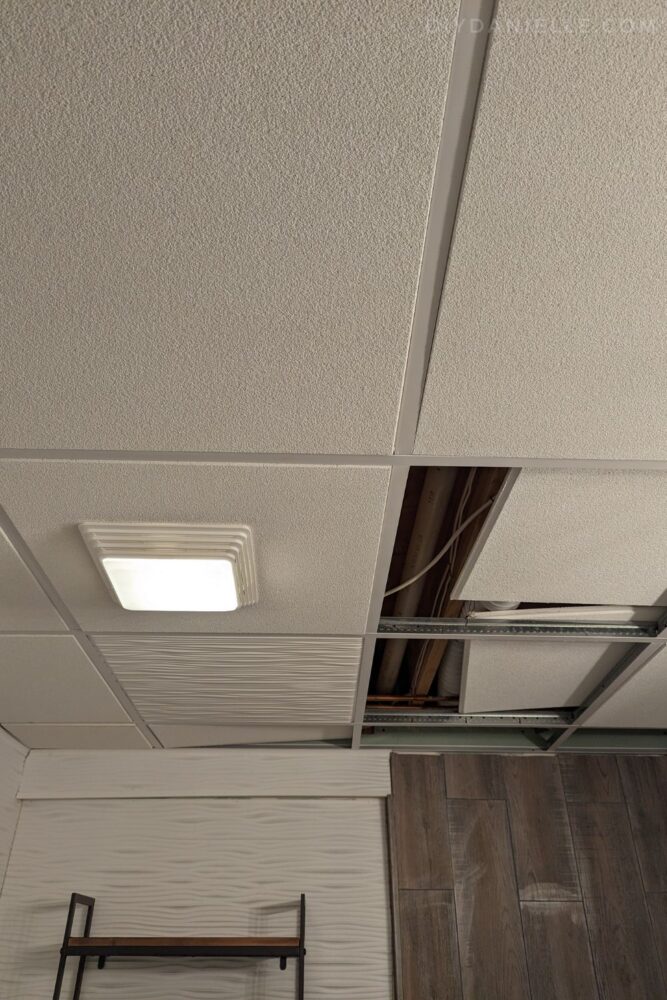 Photo of our old ceiling tiles (the ones that look like popcorn ceilings) vs. one Genesis tile installed.