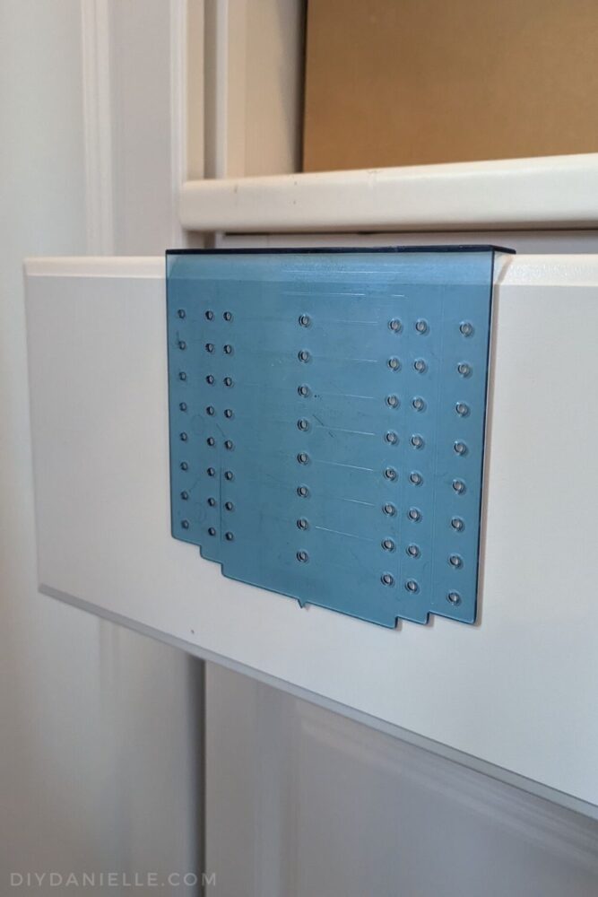 Using a template to make markings on a drawer front for drawer pulls.