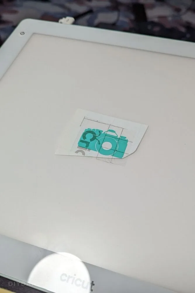 Small camera image in teal with Cricut transfer tape on top.