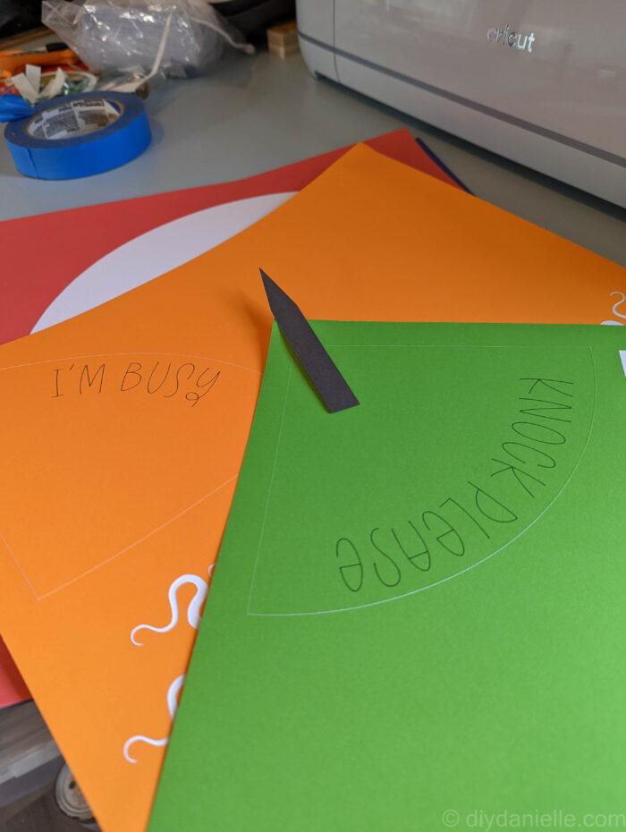 SmartSticker Cardstock in orange, green, and red with writing on them for the paper clock. They say "Knock Please" and "I'm Busy"