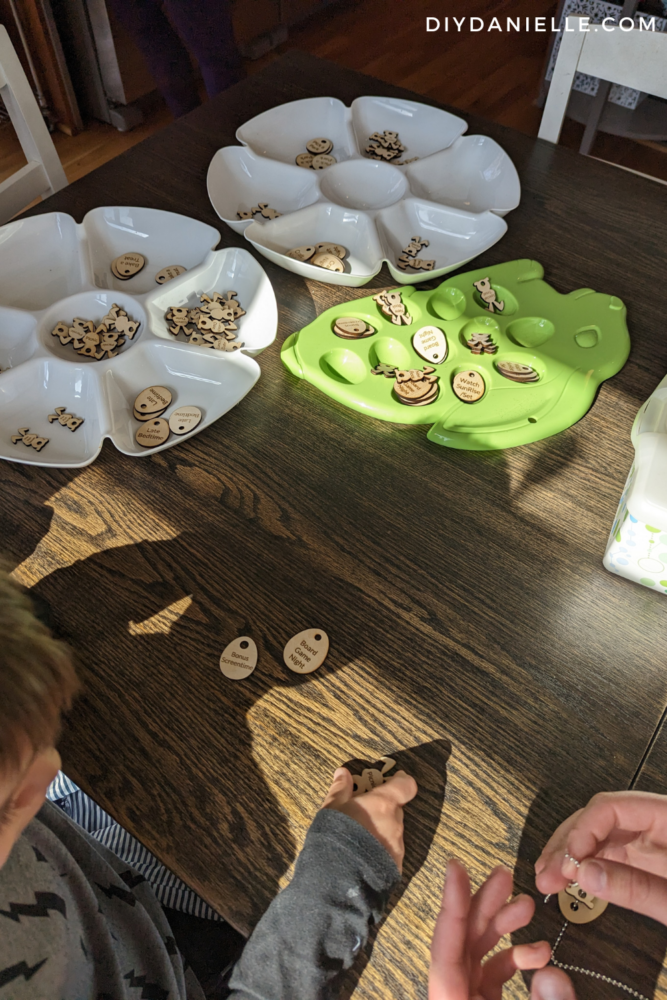 Easter tokens sorted onto different plates so kids can each pick five that they want to keep on a necklace.