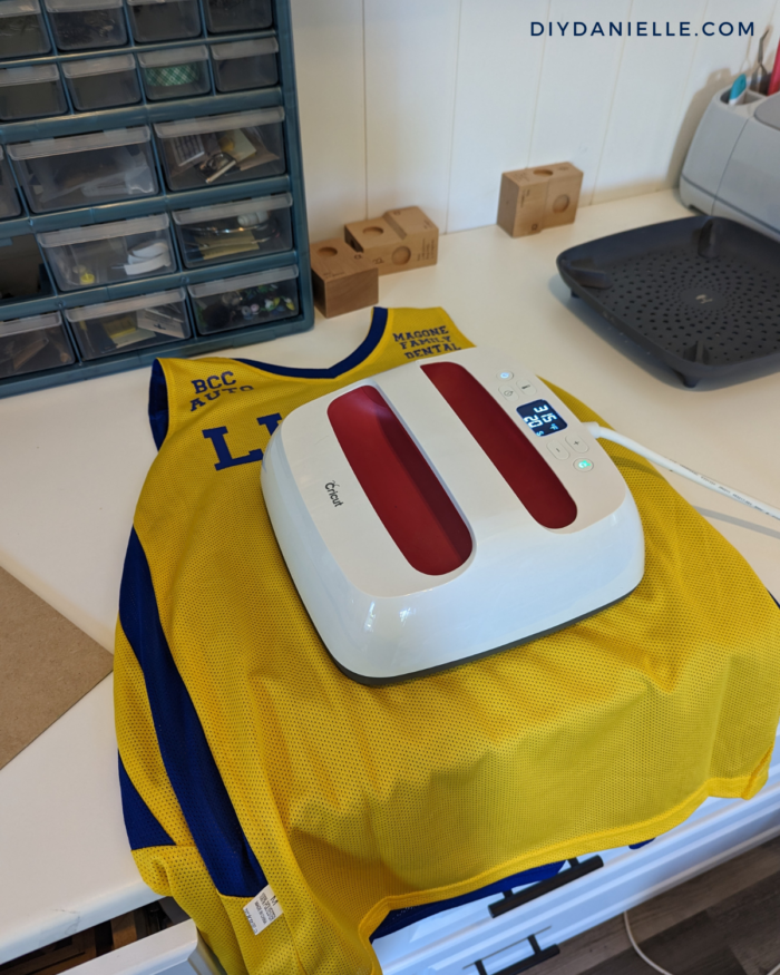 Pressing iron on vinyl on basketball jerseys for our school game.