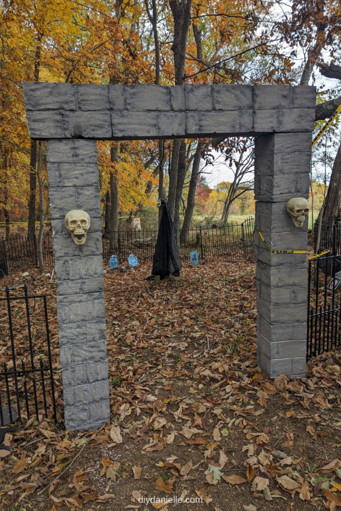 Here is the final picture of the cemetery entrance made of foam blocks and plastic skulls. Because I didn't have them mounted to the ground well (yet), I used caution tape and also fishing line to hold them in place next to the no dig dog fence that I'm reusing.