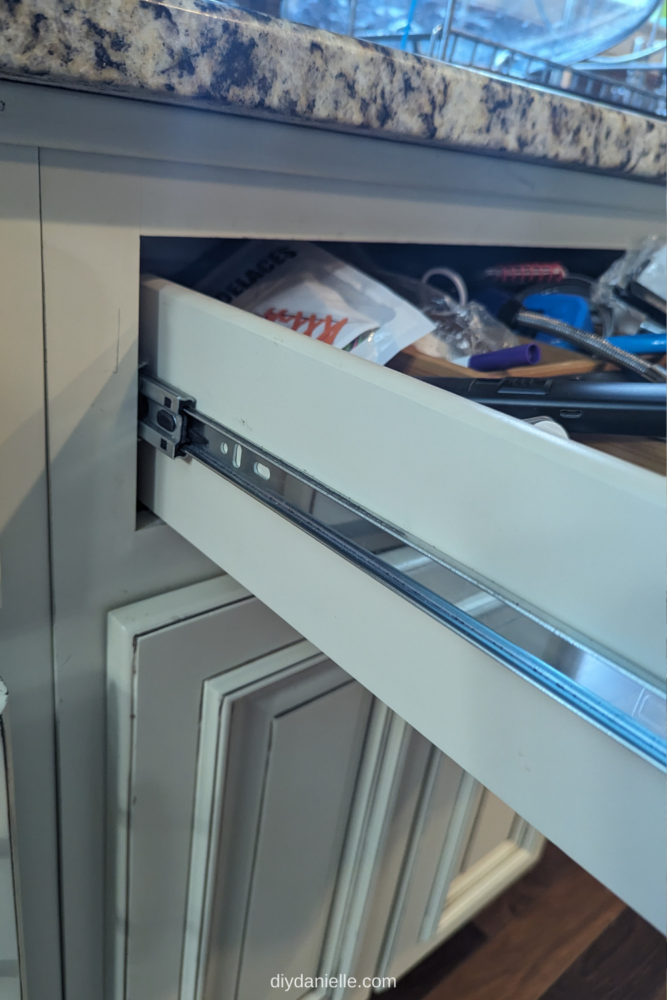 Drawer Slides: Side Mount Rails with Ball Bearings, installed on the side of a kitchen cabinet drawer.