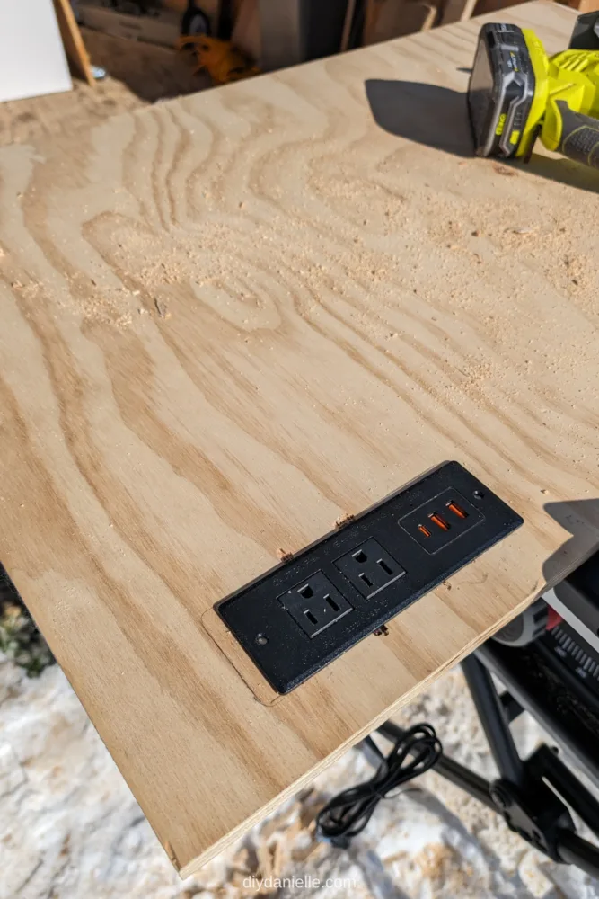The plywood countertop with the outlet installed.
