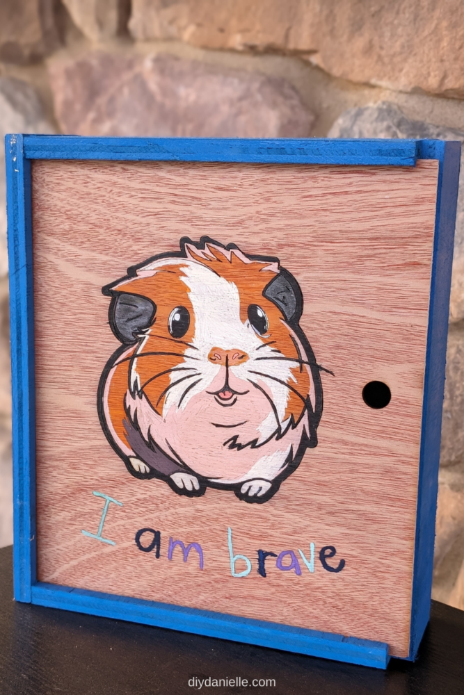 Memory Box with a Painted Guinea Pig on the Front that says "I am brave." The top opens and you can see a painted turtle on the inside that says "breathe." 