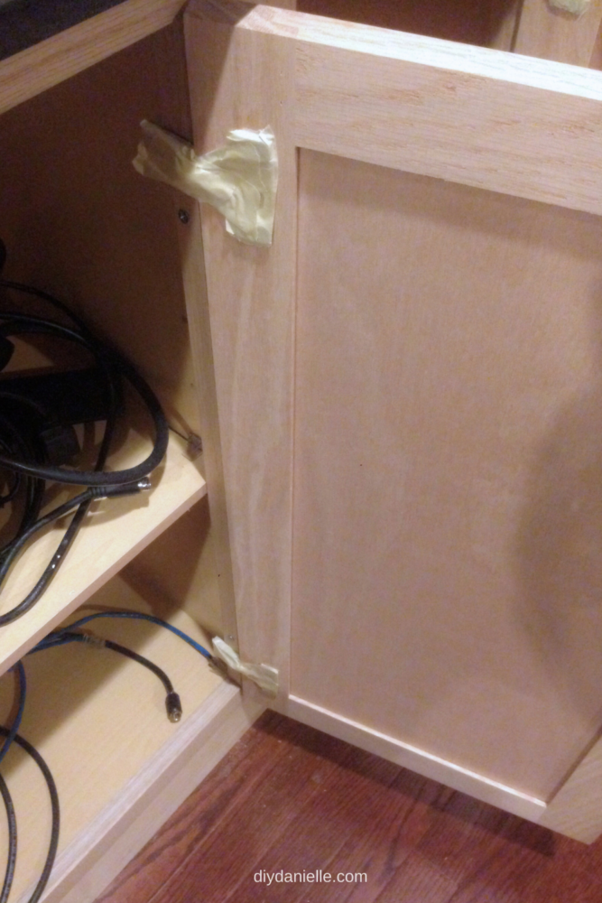 Using masking tape to keep paint off the hinges to the cabinet doors. I should have just removed the doors and hinges. 