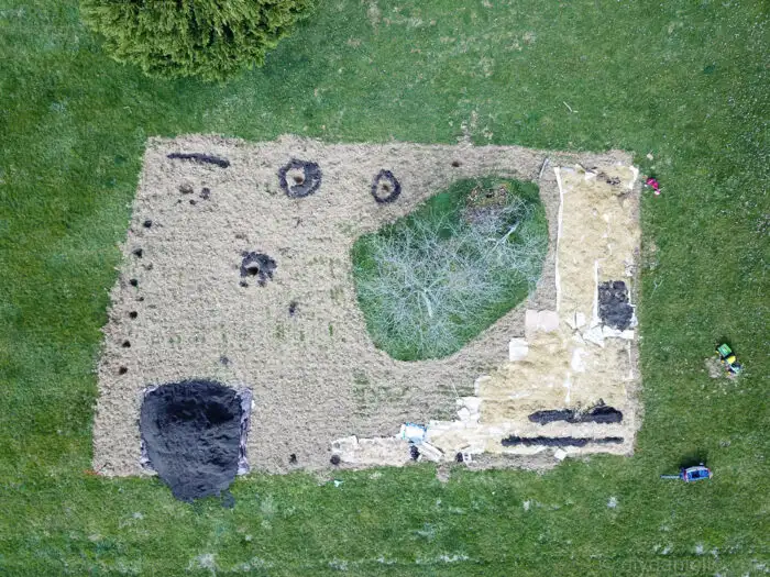 Drone view of initial food forest setup showing cardboard weed barrier and compost layering in garden space.