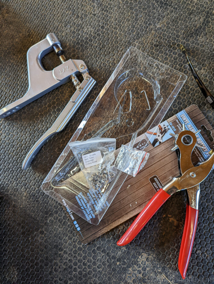 Supplies for DIY Tarp with Grommets:

Shown:
Grommets
Grommet Pliers
Rotary Hole Punch