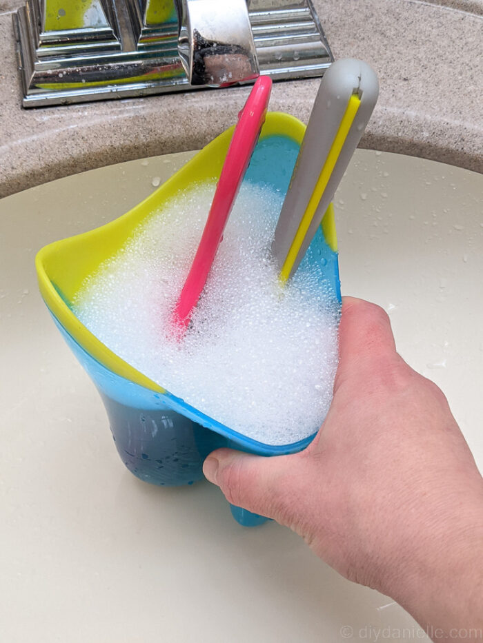 blue container with 2 dipped combs bubbles forming around it.