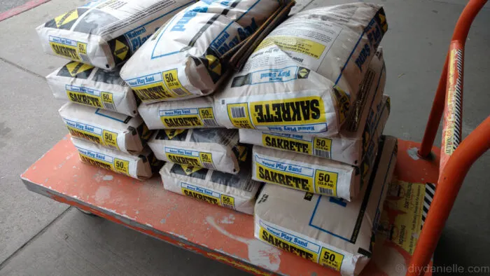 a push cart with 12 sandbags divided into 3 are filled and stacked together