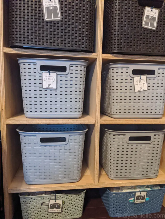 DIY Closet System for Shared Kids' Room: This plywood shelf system has eight spots divided into two columns with clothing storage for pants, pajamas, shorts, and shirts for two different kids. 