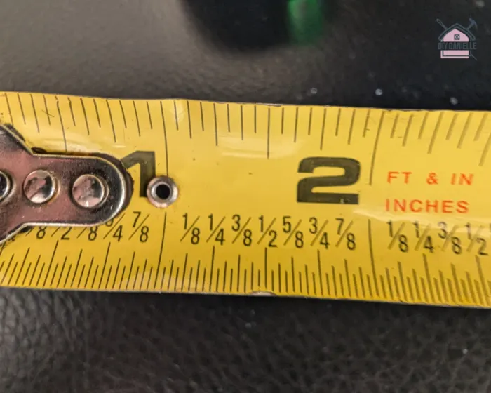 the tip of the tape measure showing half of the metal handle of the end. a visual representation of the tape measure from 0 to 1 inch. There are markings for 1/8 inches and 1/4 inches