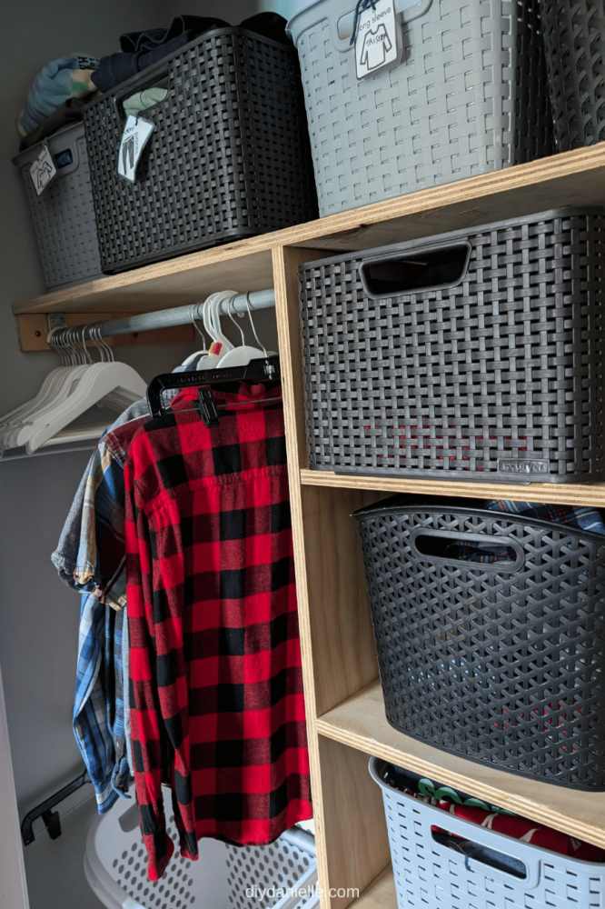 After photos of an organized closet with shelving for plastic bins. Flannel kids shirts are hanging up, there's a plastic hamper on wheels underneath the hanging clothes, and there are bins.