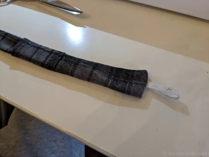 close-up of a fabric guitar strap with an elastic loop visible on the outside end.