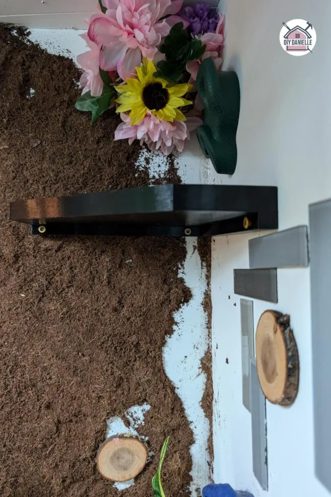 This is a photo showing the underneath of the basking ledge. There's four screw holes to use but I found the corner to be a little tricky so I only put one screw in the corner.