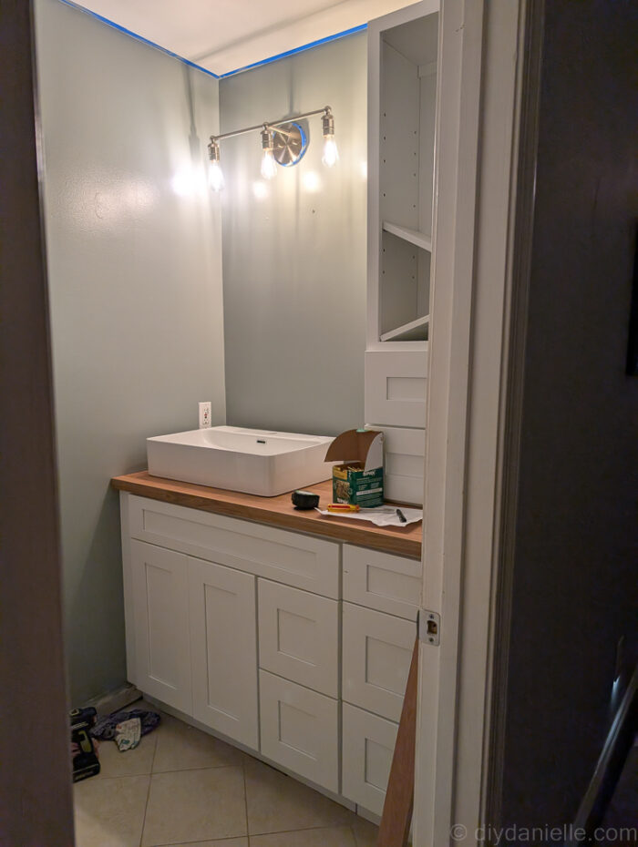 In the process of adding the sink and hardware to the bathroom. White Aspen Shaker Cabinets from the RTA Store and IKEA Saljan countertops.