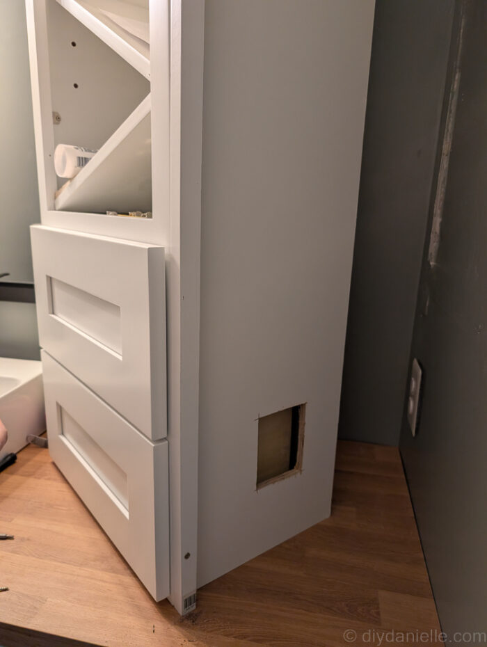 We cut out the side of the cabinet in case we need to access the hidden outlet. This will not be visible unless we remove the drawers.