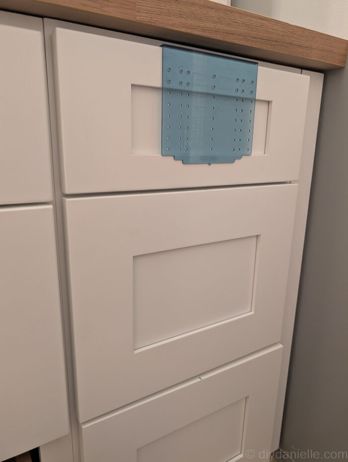 Using a template to mark where the cabinet pulls will be placed.