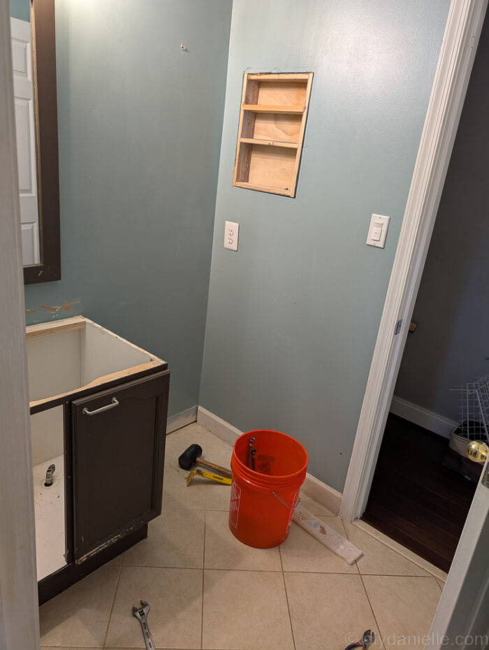 Original brown bathroom cabinet. We cut the original cabinet in half to ditch the vanity section, but used this for a couple of years. It's UGLY.  This is where the vanity USED to be... we put a tall cabinet there for extra storage for a while, but it wasn't really working well for the space.