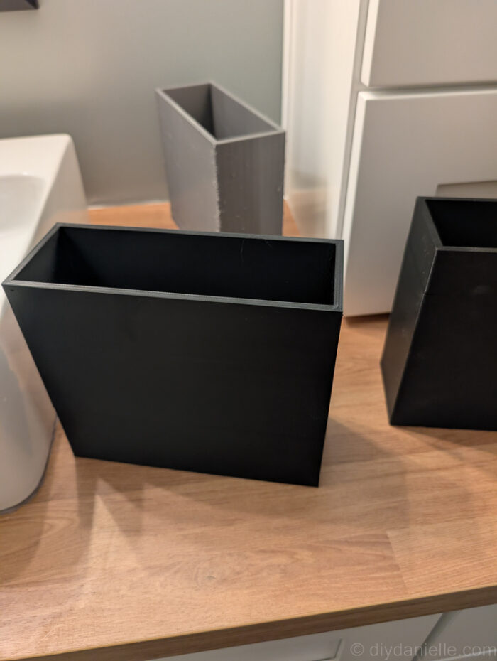 Tall 3D printed bins made with black and gray PETG to help hold items behind the sink.