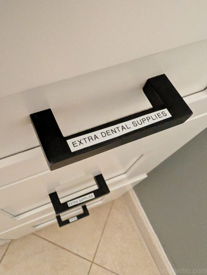 Labels on metal drawer pulls to indicate what should be stored inside the drawer.