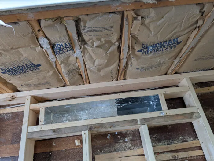 In this photo you can see the vent and some of the work they're doing to raise the vent and redirect it so that it won't be an inconvenient place when the door goes in.