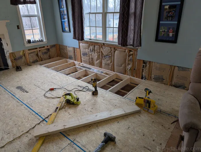 You can see in this photo how they fixed the problem from the last photo. There's one long 2x6 all the way across the room. At this point they have started adding the subfloor on top.