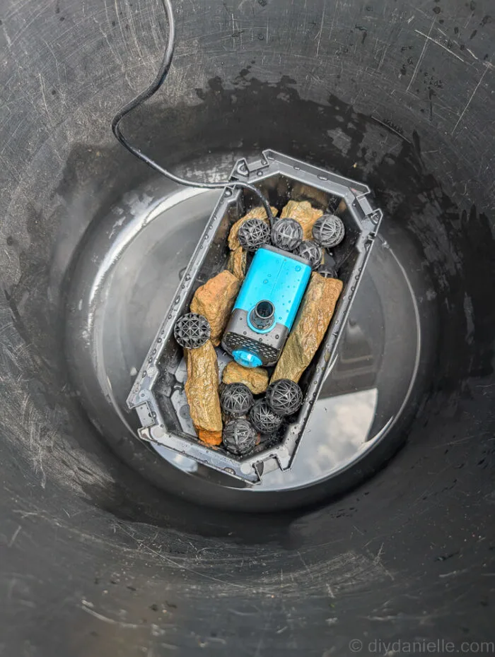 Used black muck bucket with the POPOSOAP Pond Filter with Pump Fountain Kit, 660GPH placed in the bottom. No water has been added yet. I have begun assembling the kit, adding rocks to the bottom of the box to help weigh it down in the water.