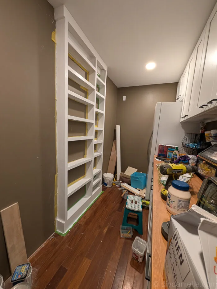 Shelves nearly complete with caulk around the edges for a smooth, finished look, though final touches are still pending in the room.
