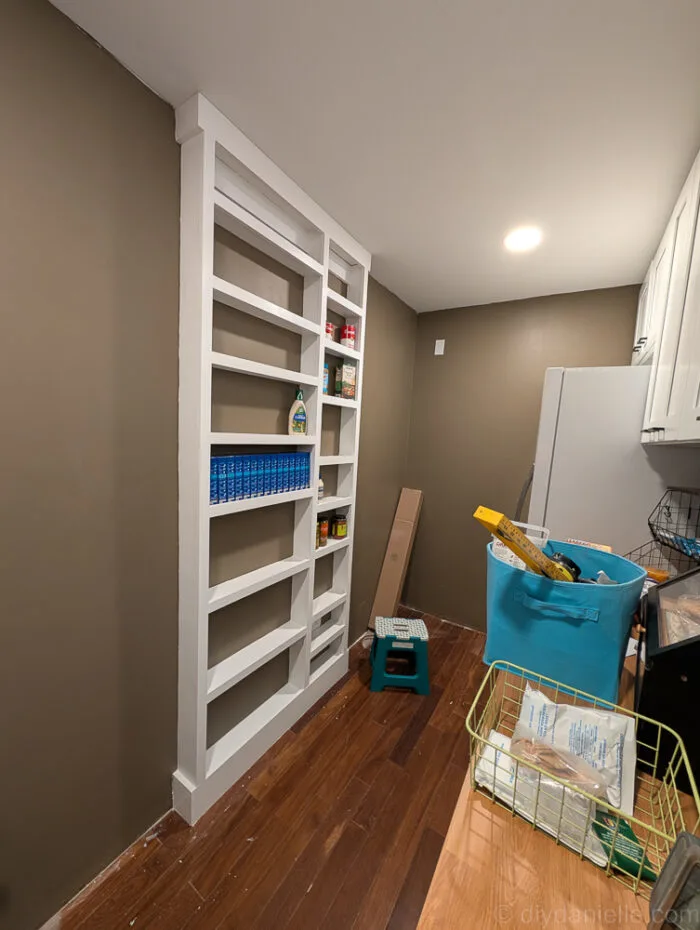 Shelves filled, with a moment of contemplation about whether to add more shelves to the setup.