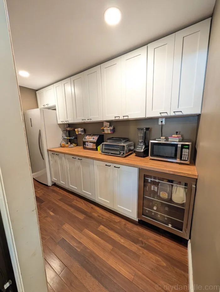 Pantry and mudroom hallway conversion, showcasing clean, functional design with IKEA wood countertops and custom shelving