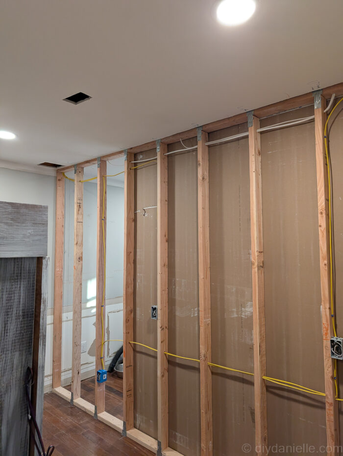 We placed some of our drywall panels before the electrician came: specifically ones that wouldn't interfere with his work. The rest we left off until he finished.